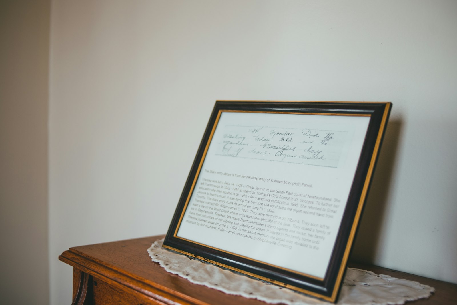 Marco de graduación con placa grabada sobre un escritorio.