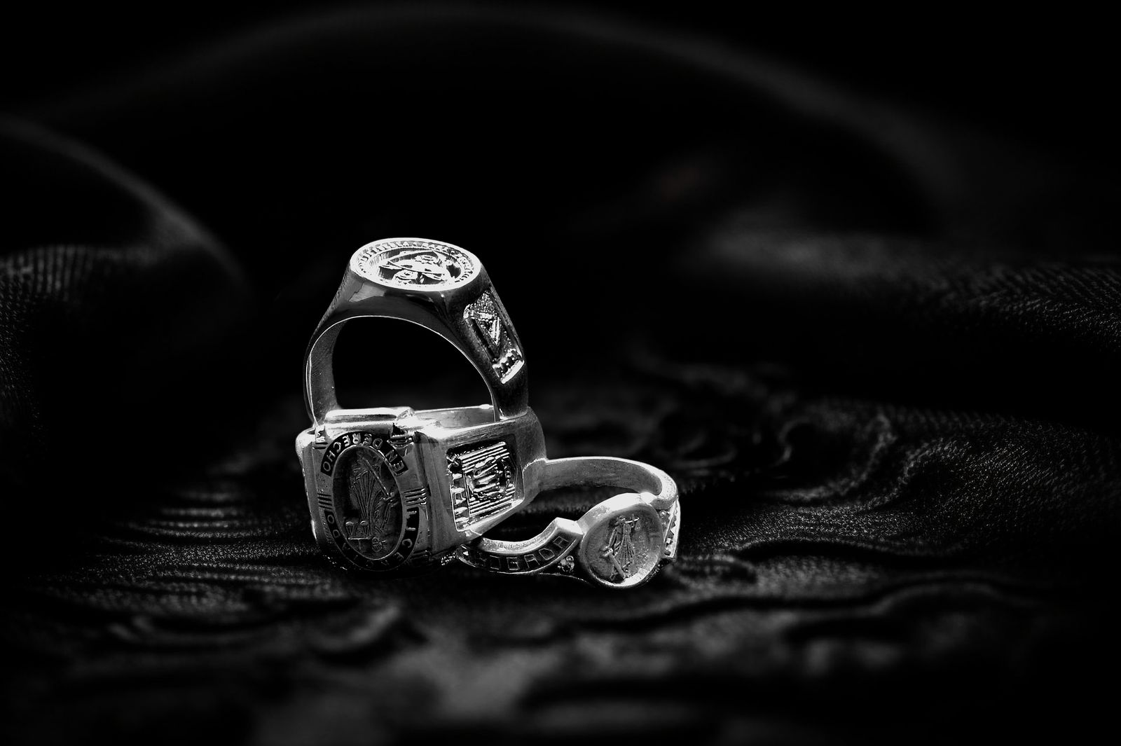 Tres anillos de graduación de plata con distintos grabados.