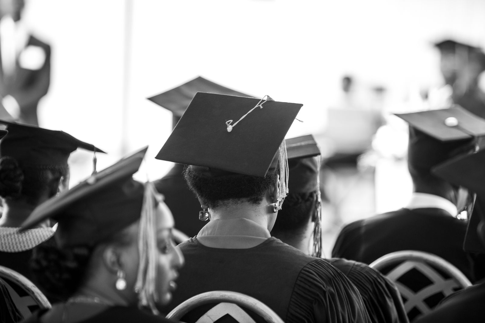Toga de graduación colgada junto a un birrete con borla, listas para una sesión fotográfica escolar.